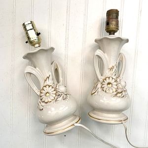 Vintage White Gold Vanity Lamps, Pair, White with Gold Accent Paint, Porcelain Lamps, Raised Flowers, Relief, Urn Style Handle added by Serena Finnerty